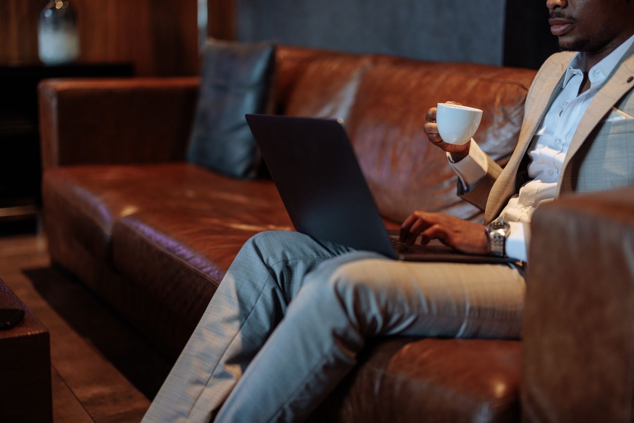 Business owner planning 2026 marketing strategy on a laptop from a leather sofa.