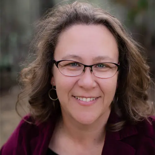 Jennifer Folsom, a woman with brown hair and glasses smiling at the camera.